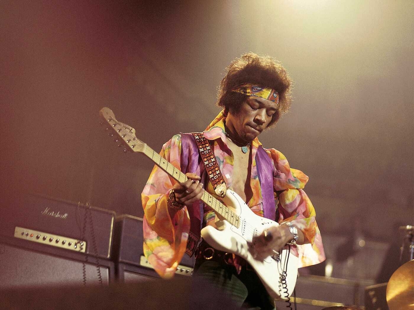 Jimi Hendrix playing the guitar on stage
