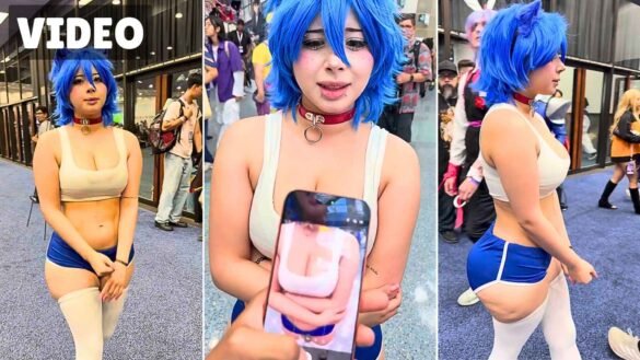 Yukiphoriaa in blue Sonic cosplay at Anime Expo showing a fan's phone photo on the convention floor