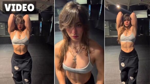 Monica Granda raising her arms while showing off her physique in the gym